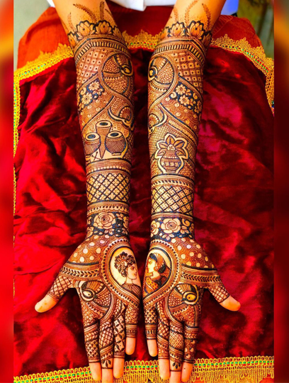 Professional artist applying hand Mehandi designs with organic henna