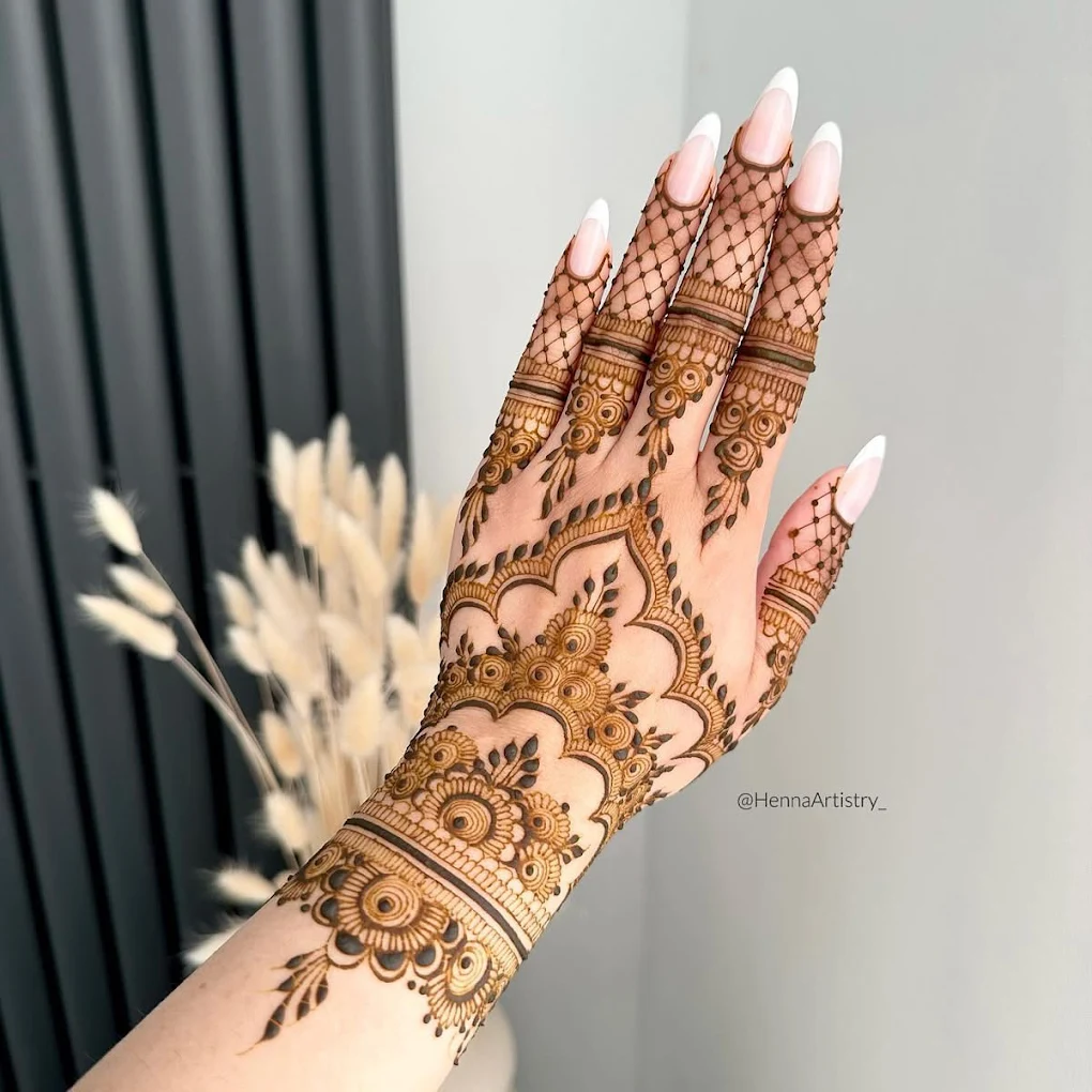 Professional artist applying hand Mehandi designs with organic henna