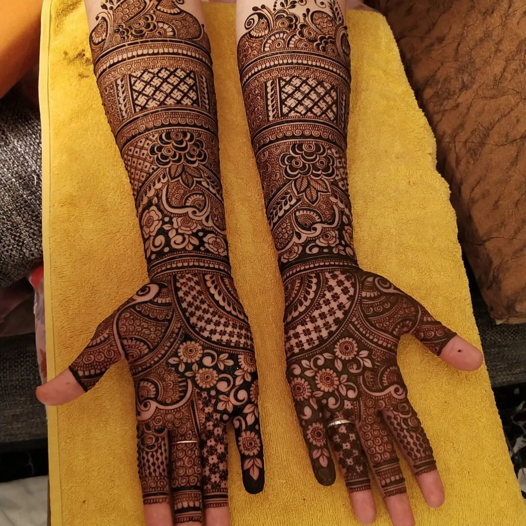 Professional artist applying hand Mehandi designs with organic henna