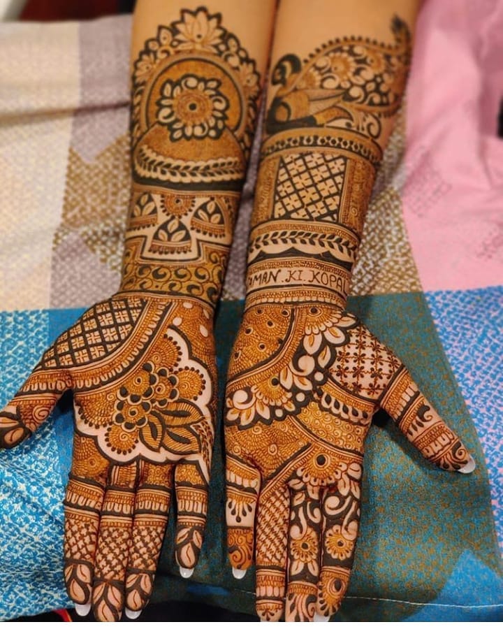 Professional artist applying hand Mehandi designs with organic henna