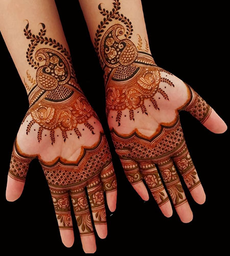 Professional artist applying hand Mehandi designs with organic henna