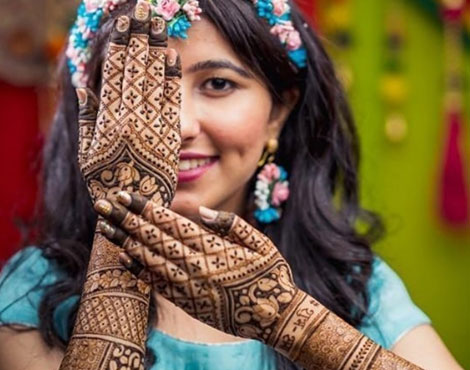 Professional mehandi artist in Ghaziabad applying bridal henna design