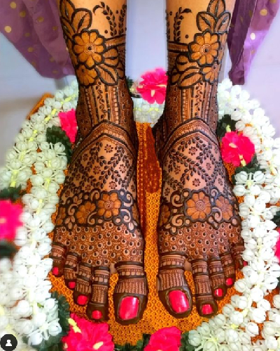 Professional Foot Mehndi Artist applying intricate bridal foot henna design