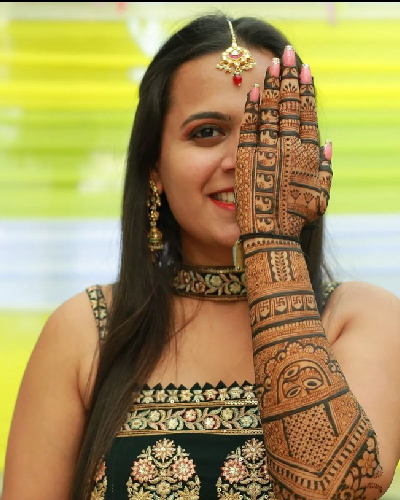Professional artist applying hand Mehandi designs with organic henna